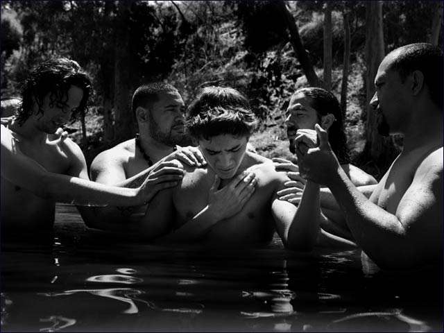 A young Maori pilgrim from New Zealand prays as he is about to be baptized in the Jordan River in Israel.