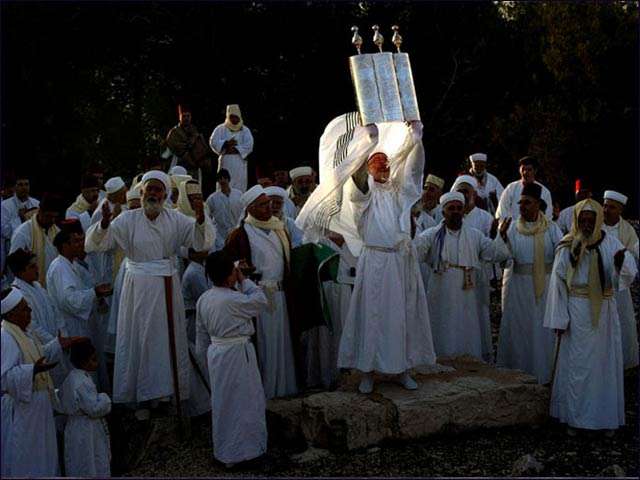 A senior priest of the tiny ancient Samaritan community holds a Tora scroll, during the pilgrimage for The Holy day of Tabernacles (Sukkot), at their most sacred site at Mount Gerizim in the northern West Bank.