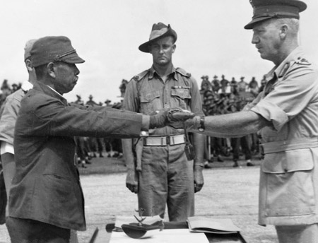 Hatazo Adachi, comandante del 18° Ejército japonés en Nueva Guinea, rinde su espada ante el comandante de la Sexta División (Australia), Horace Robertson.