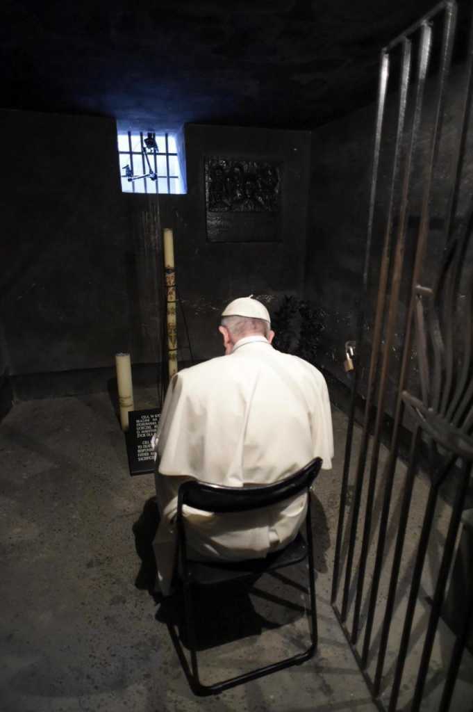 Francisco  reza en la celda subterránea en la que murió de inanición el sacerdote polaco Maximiliano Kolbe, quien ofreció su vida a cambio de la de un padre de familia que iba a ser asesinado (EFE)