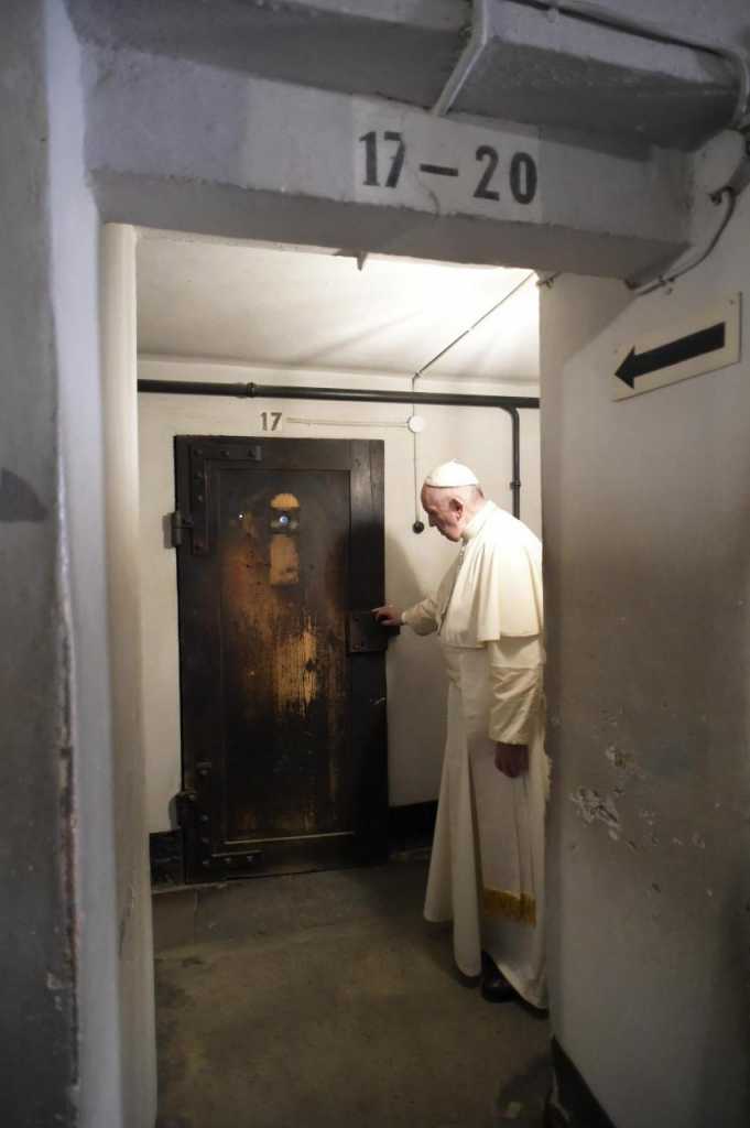 Francisco en la puerta de la celda subterránea en la que murió el sacerdote polaco Maximiliano Kolbe (EFE)