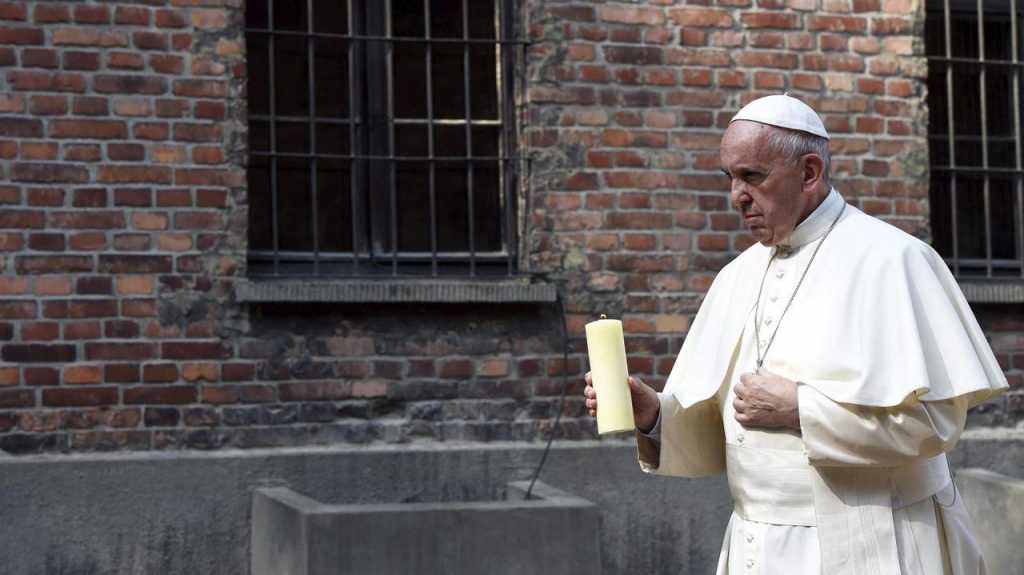 El papa Francisco enciende una vela ante el “muro de la muerte” (EFE)