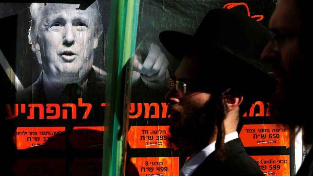 Un judío ultraortodoxo pasa junto a un póster de Trump en Jerusalén.