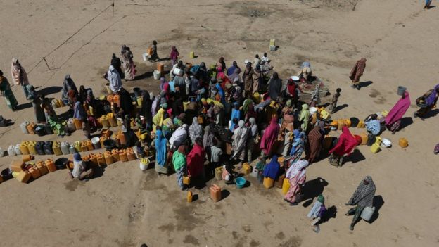 Mujeres y niños reunidos en el dispensario de agua en el capo de refugiados de Muna, en Maiduguri, Nigeria.