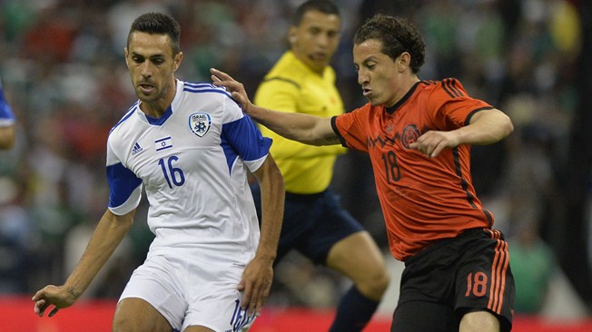 Mexico's foward Andres Guardado (R) disputes the ball with Israel's Eran Zahavi