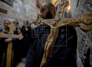 Un fiel carga con una cruz durante una oración en la Iglesia del Santo Sepulcro tras finalizar una procesión de Viernes Santo por la Vía Dolorosa en el casco viejo de Jerusalén (Israel) hoy, 14 de abril de 2017. EFE