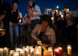 Dolientes encienden velas durante una vigilia en la esquina de Sahara Avenue y Las Vegas Boulevard para las víctimas del tiroteo de la noche del domingo 2 de octubre de 2017 en Las Vegas, Nevada. (Drew Angerer / Getty Images / AFP)