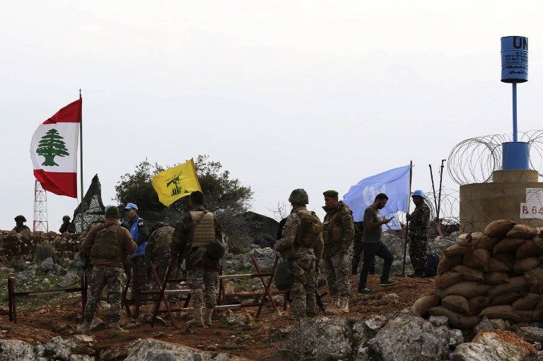 Una fotografía tomada desde la aldea sur de Líbano, Meiss al-Jabal, el 16 de diciembre de 2018, muestra a soldados israelíes observando a los soldados de las Fuerzas Provisionales de las Naciones Unidas en el Líbano (UNIFIL) hablar con soldados libaneses frente a una bandera de Hezbolá. (Mahmoud ZAYYAT / AFP)