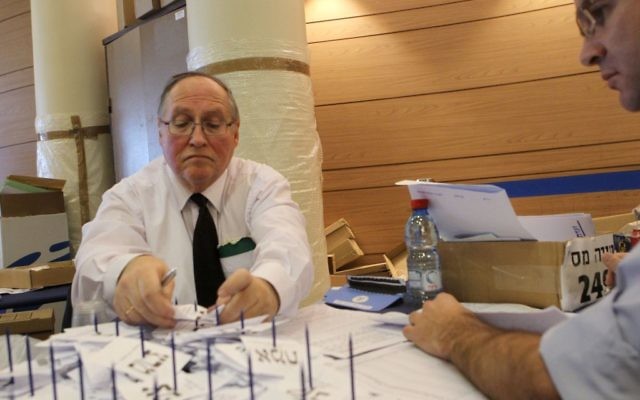 Judge Elyakim Rubinstein, head of the Central Election Committee, tallying votes in Jerusalem on Tuesday. (photo credit: Miriam Alster/Flash90)