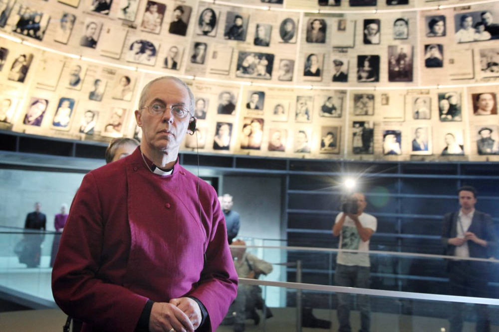 El actual arzobispo de Canterbury y obispo principal de la Iglesia de Inglaterra, Justin Welby, mira hacia arriba y a su alrededor fotografías de víctimas individuales del Holocausto en el Salón de los Nombres en el museo Memorial del Holocausto Yad Vashem en Jerusalén. 27 de junio de 2013. (Isaac Harari / FLASH90)