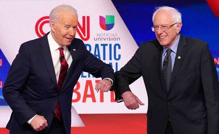 Imagen de archivo de los aspirantes presidenciales demócratas Joe Biden (izq) y Bernie Sanders saludándose con los codos antes del comienzo de un debate en Washington, EEUU. 15 marzo 2020. REUTERS/Kevin Lamarque
