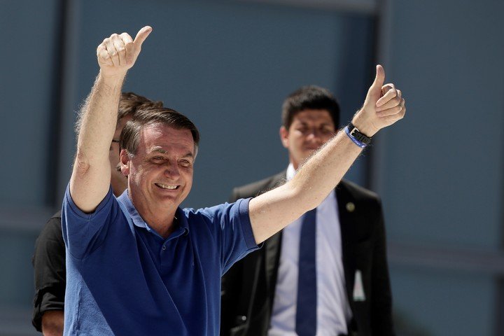 Bolsonaro saluda a seguidores durante una marcha, el domingo. / AP