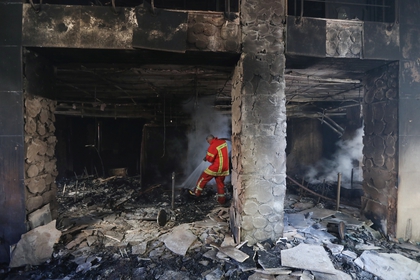 Un bombero rocía agua dentro de una sucursal de banco abandonada que fue incendiada durante las protestas nocturnas en Beirut, Líbano, el 12 de junio de 2020 (REUTERS/Mohamed Azakir)