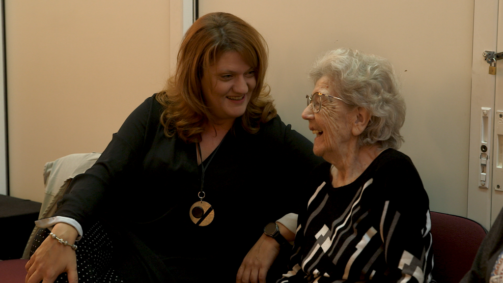 Julia Dandolova laughs with an elderly community member.
