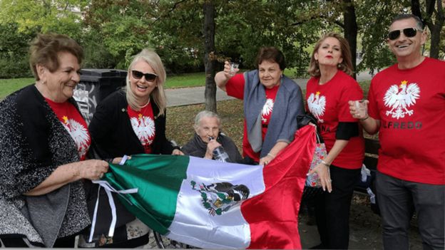 Valentina y Frania junto a familiares con una bandera mexicana.