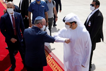 El asesor de seguridad nacional israelí Meir Ben-Shabbat se codea con un funcionario de los Emiratos Árabes Unidos mientras se dirige a abordar el avión que saldrá de Abu Dhabi, Emiratos Árabes Unidos, el 1 de septiembre de 2020 (REUTERS/Nir Elias//Archivo Foto)