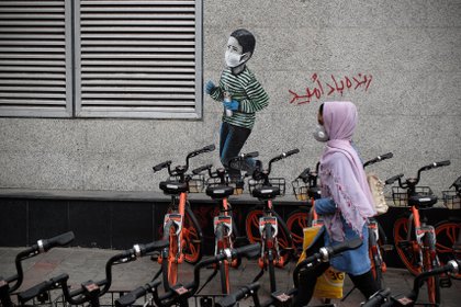 30/04/2020 Una mujer pasa junto a un mural de un niño con mascarilla en Teherán, IránPOLITICA INTERNACIONAL Rouzbeh Fouladi/ZUMA Wire/dpa 