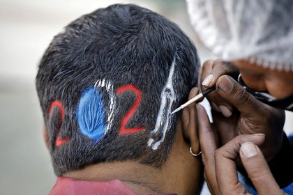 Un peluquero diseña un corte para un cliente que espera con ansias la llegada del 2021 en Ahmedabad, India. REUTERS/Amit Dave