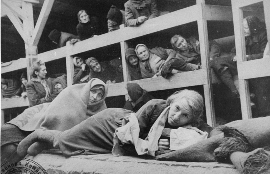 Women survivors huddled in a prisoner barracks shortly after Soviet forces liberated the Auschwitz camp. [LCID: 31450b]