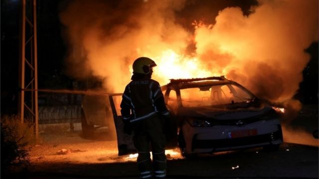 Un bombero israelí cerca de un vehículo policial incendiado el 12 de mayo de 2021.