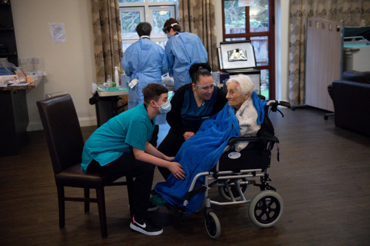 Vera Levick, residente del hogar de ancianos, de 106 años, es consolada por el personal antes de recibir una inyección de la vacuna contra el coronavirus en Andrew Cohen House en Birmingham. 