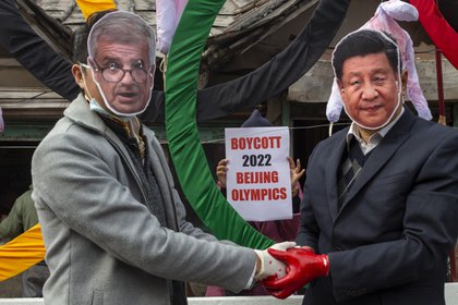 Activistas con máscaras del presidente del COI, Thomas Bach, a la izquierda, y del presidente chino, Xi Jinping, posan frente a los Anillos Olímpicos durante una protesta callejera contra la celebración de los Juegos Olímpicos de Invierno de Beijing 2022, en Dharmsala, India. (AP Photo/Ashwini Bhatia, archivo)