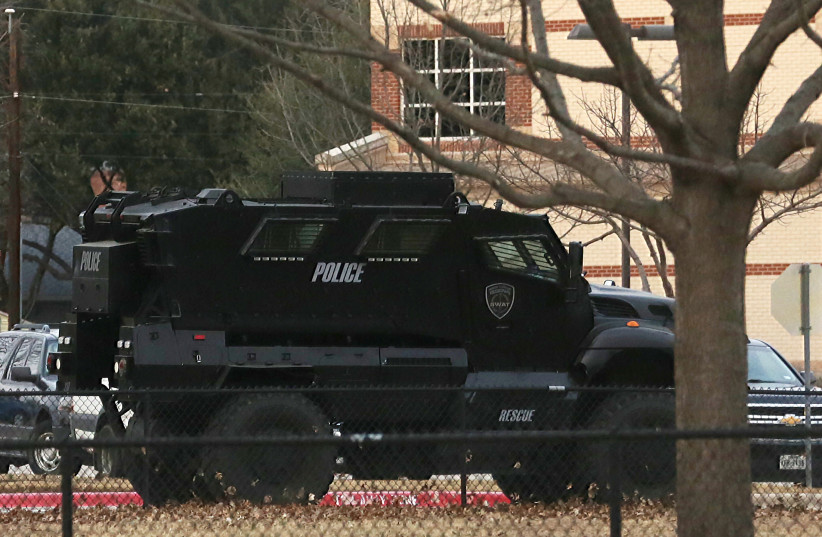  Un vehículo policial está estacionado en una escuela en el área donde se cree que un hombre tomó a personas como rehenes en una sinagoga durante los servicios que se transmitían en vivo, en Colleyville, Texas, EE. UU., 15 de enero de 2022. (Crédito: REUTERS/Shelby Tauber )
