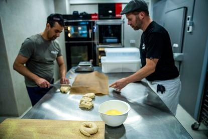 Mostafá Kamal, panadero, y Nick Sullivan, propietario de Nopa Bagels, dividen la masa de los bagels. 
